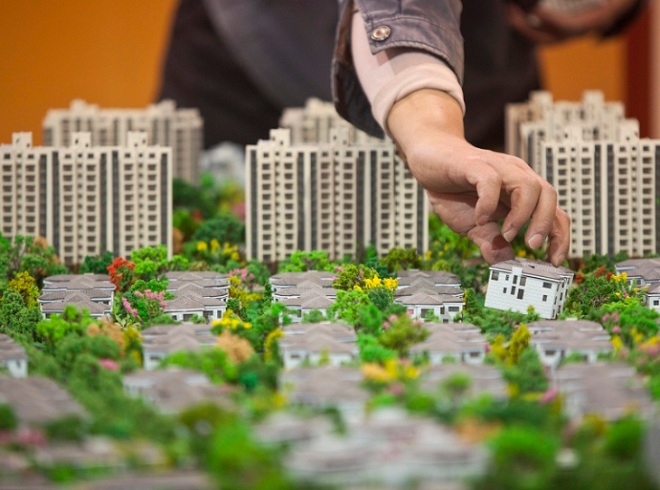 A worker installs models in preparation for a real estate exhibition in Shanghai